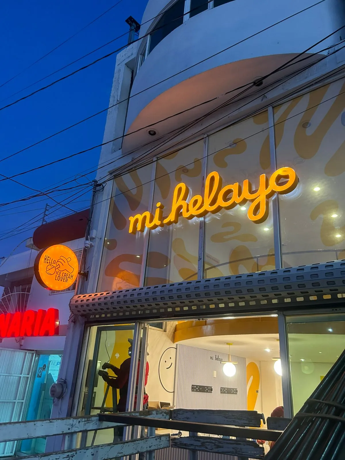 Letrero neon Mi Helayo en fachada nocturna